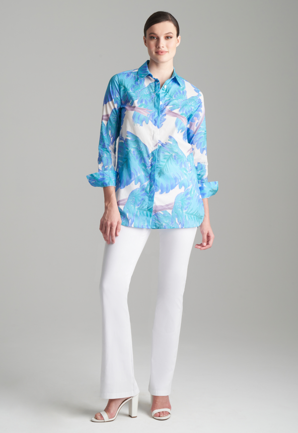 Woman wearing printed blue leaf cotton shirt top with white pants and white heels by Ala von Auersperg