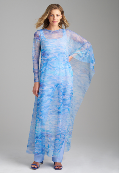 Woman wearing blue mesh ocean waves printed on armed poncho kaftan over periwinkle stretch knit tank top and pants by Ala von Auersperg for summer 2023