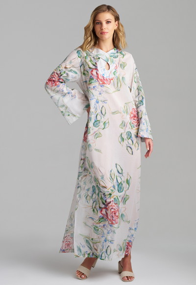 Woman wearing rose printed cotton bell sleeved long kaftan with figure 8 collar detailing by Ala von Auersperg for summer 2023