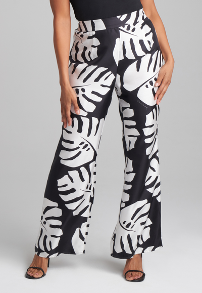 Woman wearing silk black and white palm printed wide leg pant with italian stretch cotton square neck tank top in black by Ala von Auersperg for holiday 2022