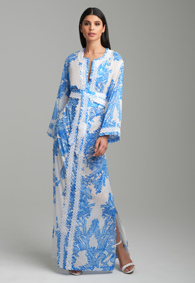 Woman wearing blue coral printed cotton voile kaftan with white trim with belt by Ala von Auersperg for resort 2023