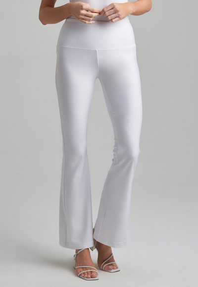 Woman wearing white stretch knit flair pants and white stretch knit tank top by Ala von Auersperg for spring summer 2021