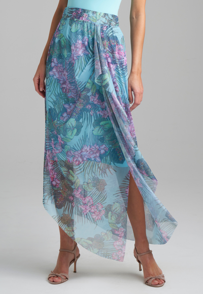 Woman wearing stretch knit tank top in blue with mesh printed orchid and palm green skirt by Ala von Auersperg for resort 2022