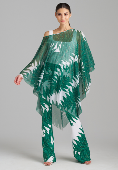 Woman wearing green palm printed mesh poncho with green palm printed stretch knit pants and white italian stretch cotton tank top by Ala von Auersperg