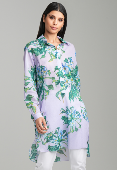 Woman wearing lavender mock coffee printed button down tunic shirt with italian stretch cotton white pants by Ala von Auersperg for resort 2023