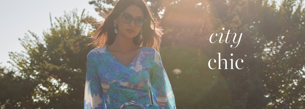 City Chic | Woman wearing blue tropical leaf printed cotton wrap top by Ala von Auersperg for women's warm weather clothing