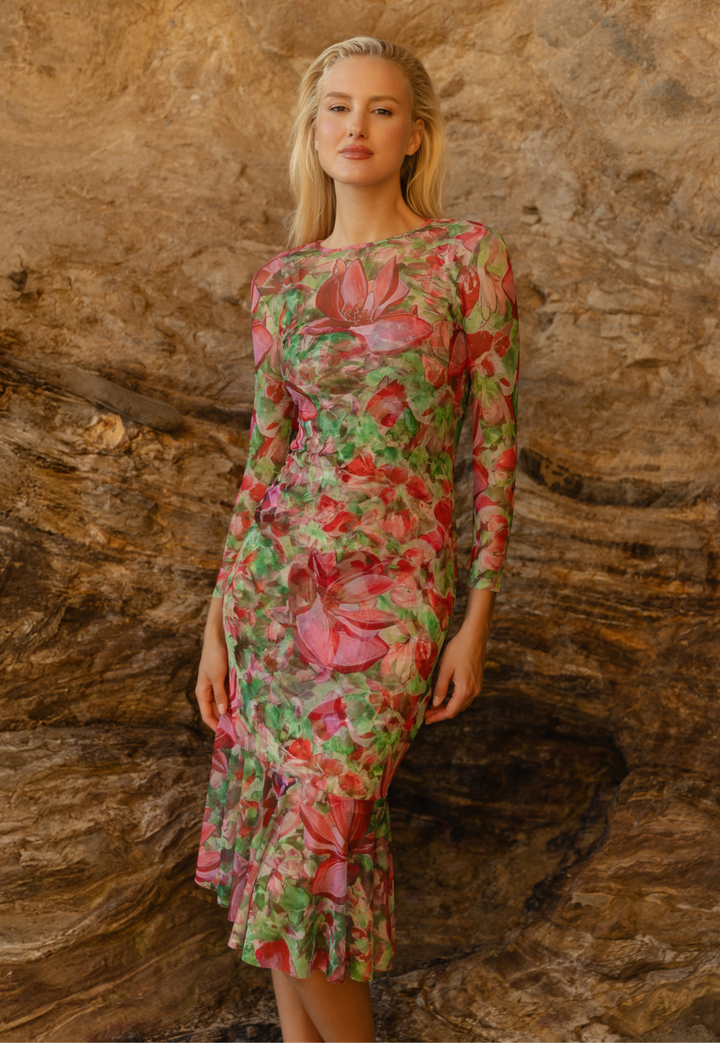 Woman wearing mesh floral dress over matching mini dress on the beach