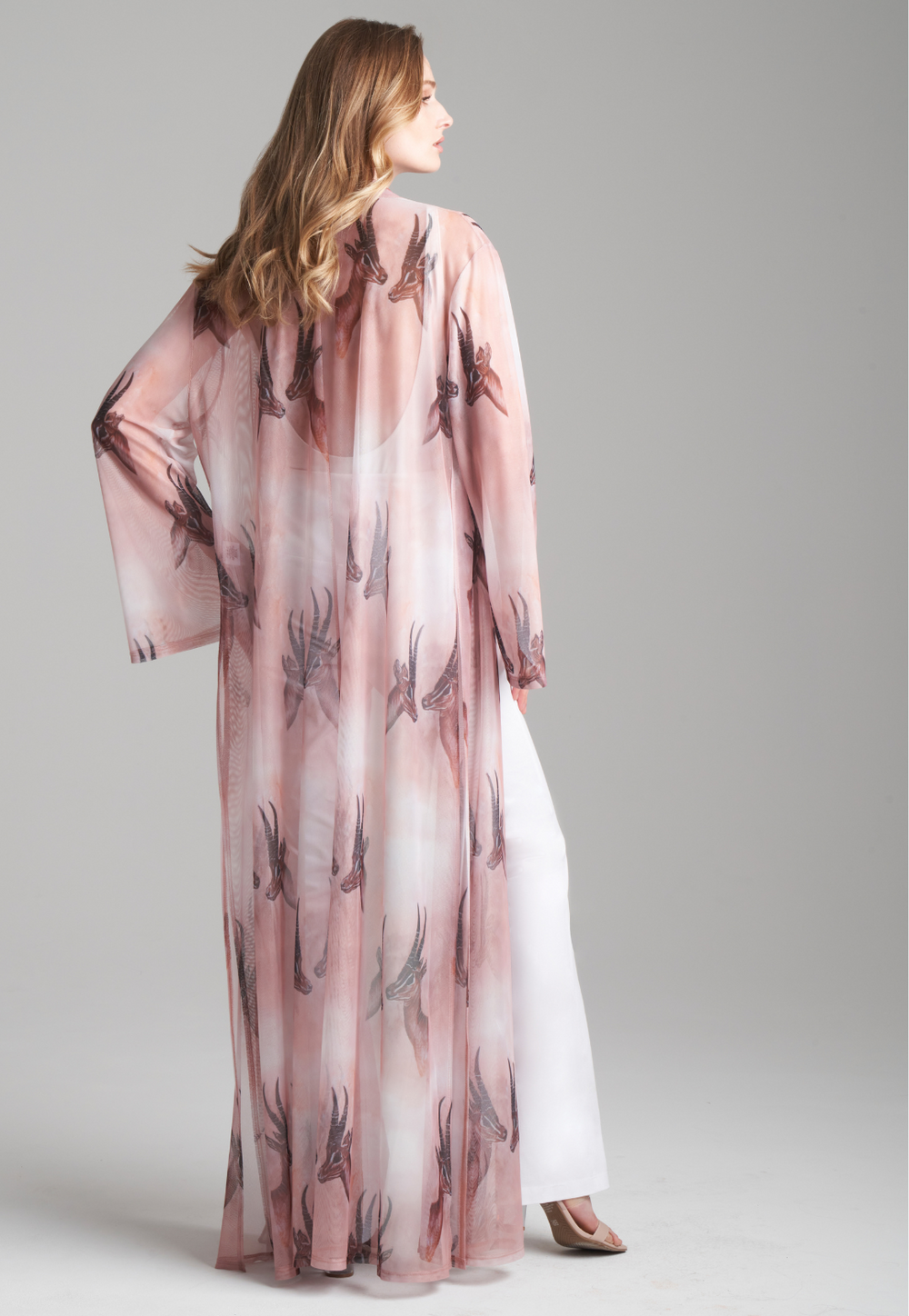 Woman wearing long mesh duster robe in brown deer print over white stretch knit tank top and pants by Ala von Auersperg for fall 2023