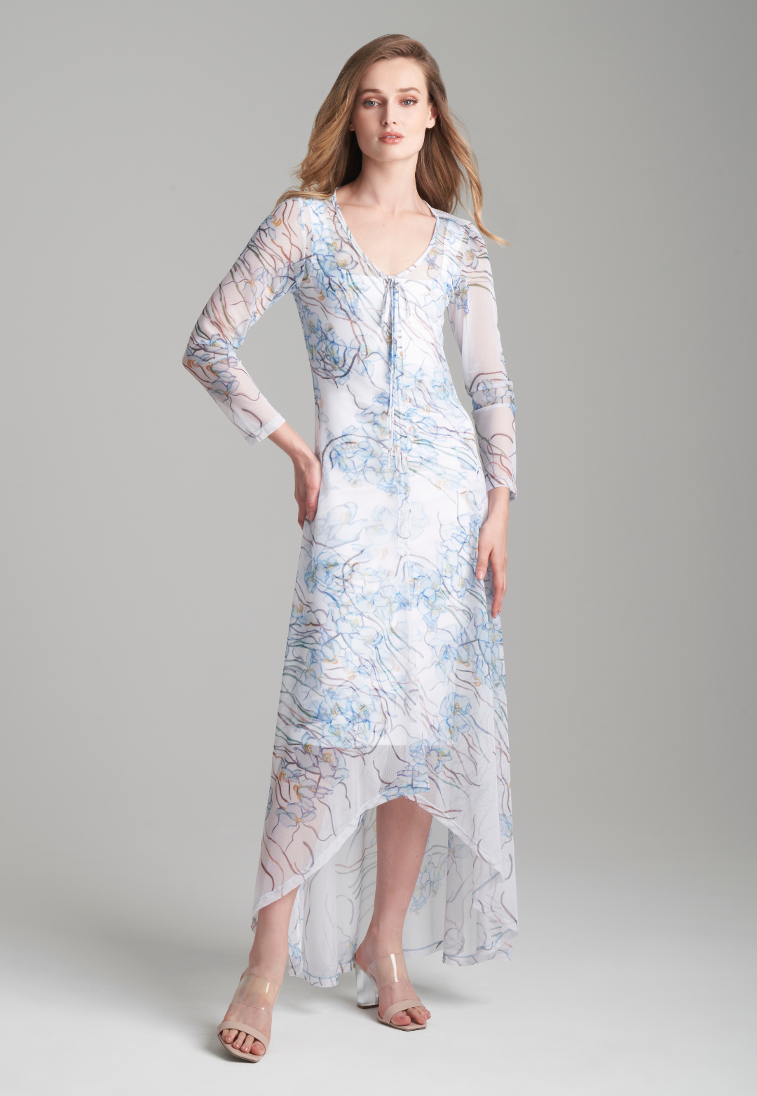 Woman wearing blue orchid printed mesh bathing suit cover up over short stretch knit white dress by Ala von Auersperg for spring 2024