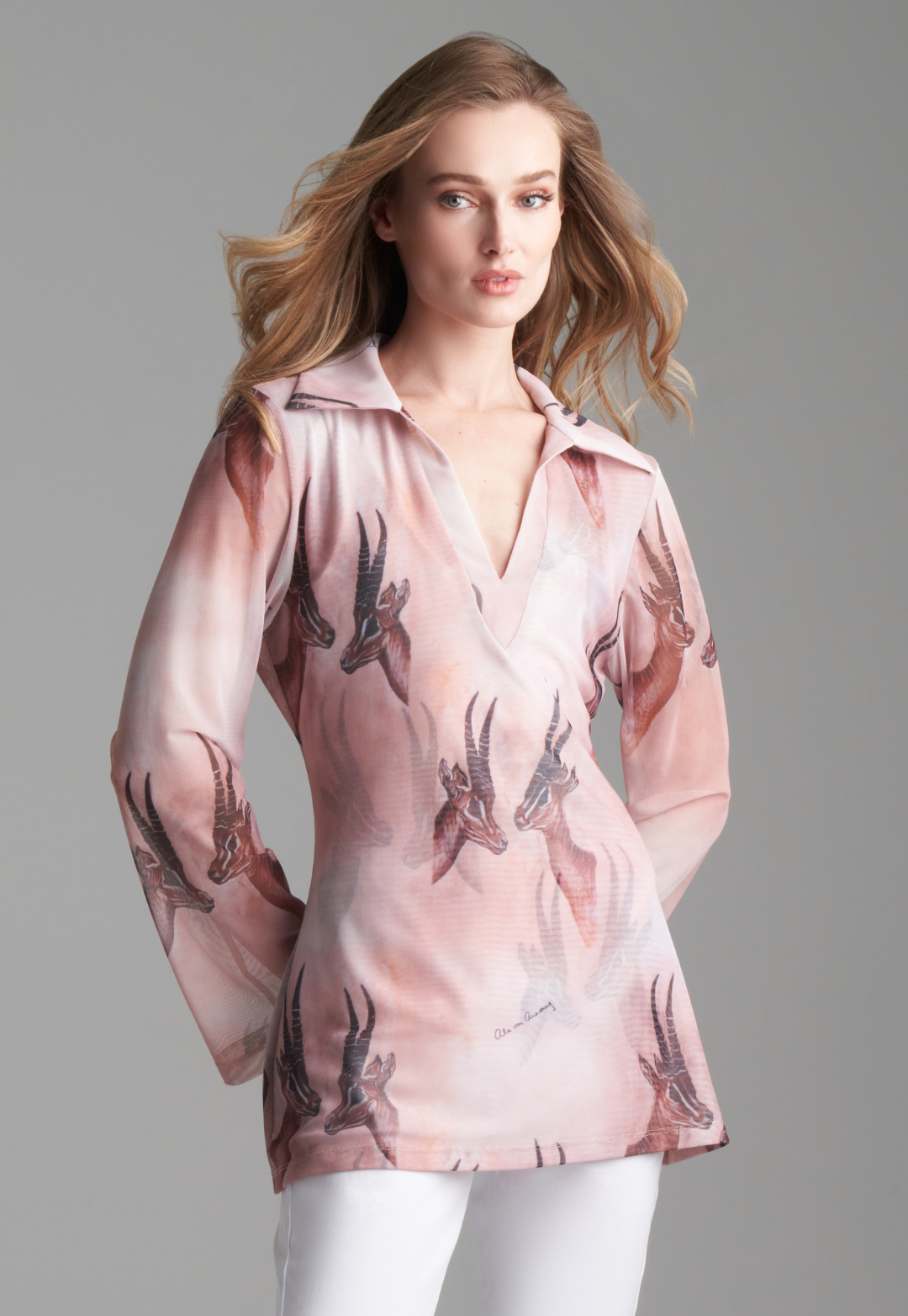 Woman wearing mesh v-neck sweater with organza collar in brown deer print paired with white stretch knit pants by Ala von Auersperg for fall 2023