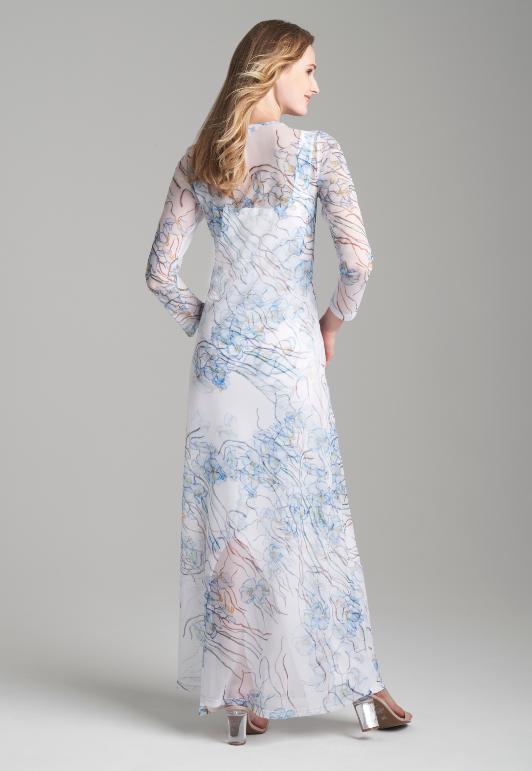 Woman wearing mesh blue orchid printed dress over a white short stretch knit dress by Ala von Auersperg for spring 2024