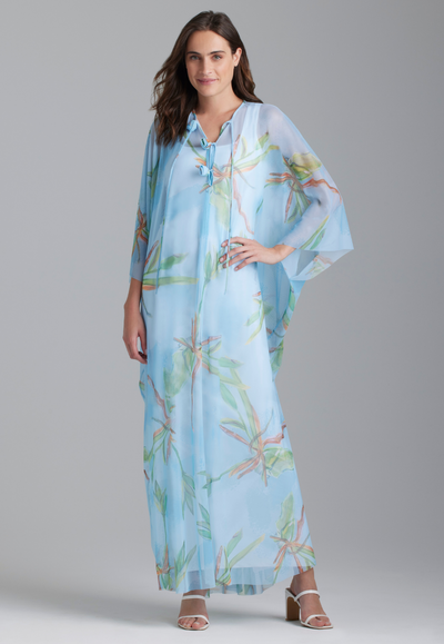 Woman wearing mesh bamboo printed kaftan with rosette detailing over white stretch knit long dress by Ala von Auersperg for resort 2024