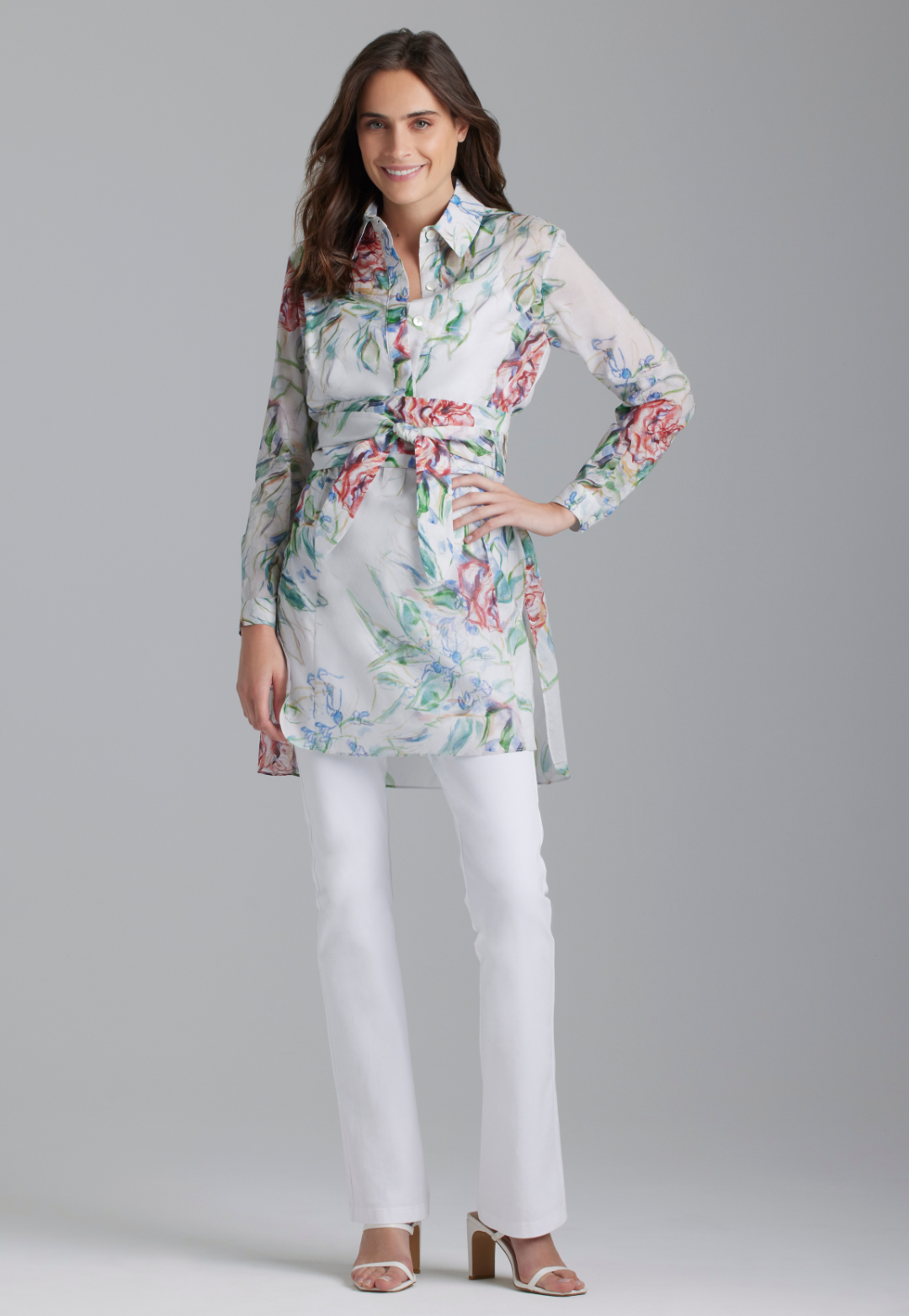 Woman wearing rose printed cotton tunic with belt and italian stretch cotton white pants by Ala von Auersperg