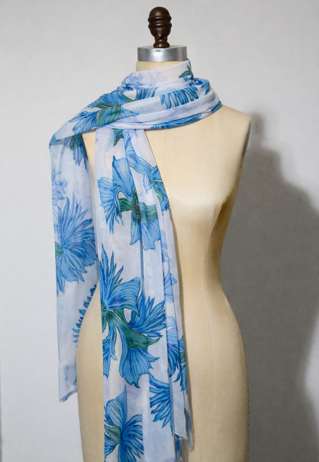 Blue floral scarf on a mannequin against a plain background