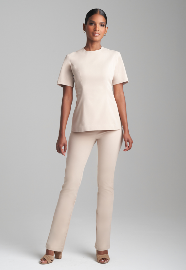 Woman wearing khaki cotton peplum top with khaki cotton stretch pants by Ala von Auersperg for fall 2023