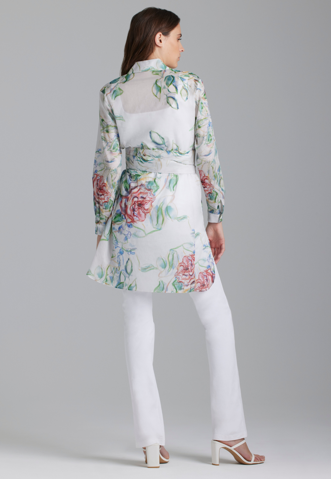 Woman wearing rose printed cotton tunic with belt and italian stretch cotton white pants by Ala von Auersperg
