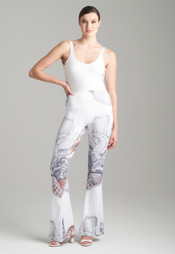 Woman wearing shell printed white stretch knit pants with white italian stretch cotton tank top by Ala von Auersperg for resort 2024