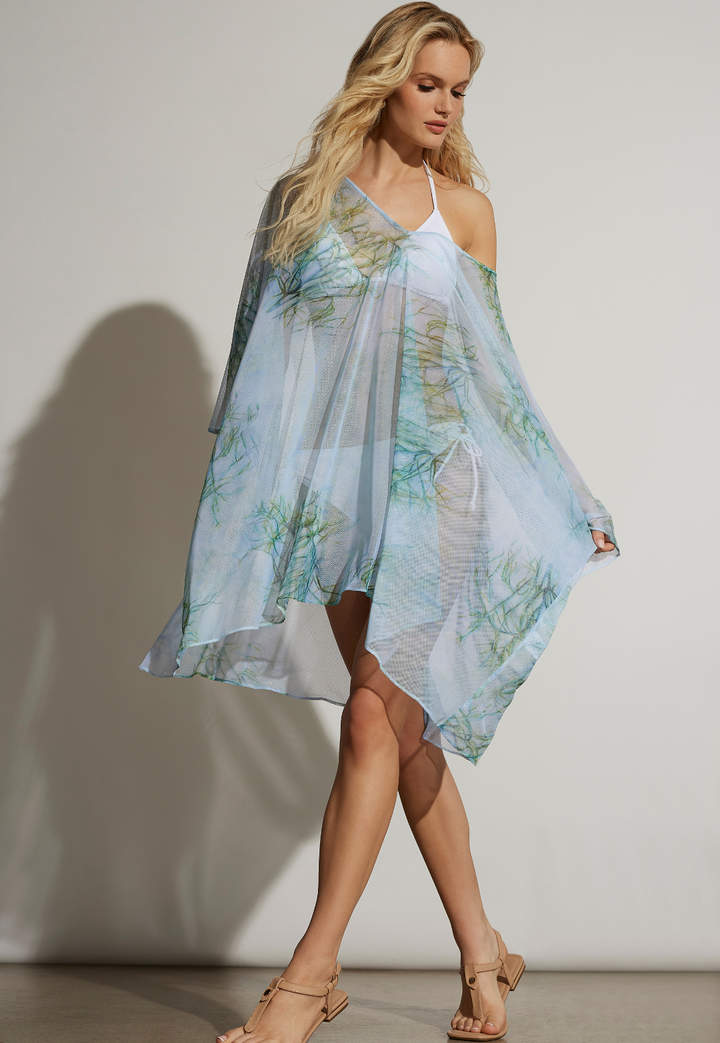 Woman wearing light blue and green printed mesh kaftan over a white bikini