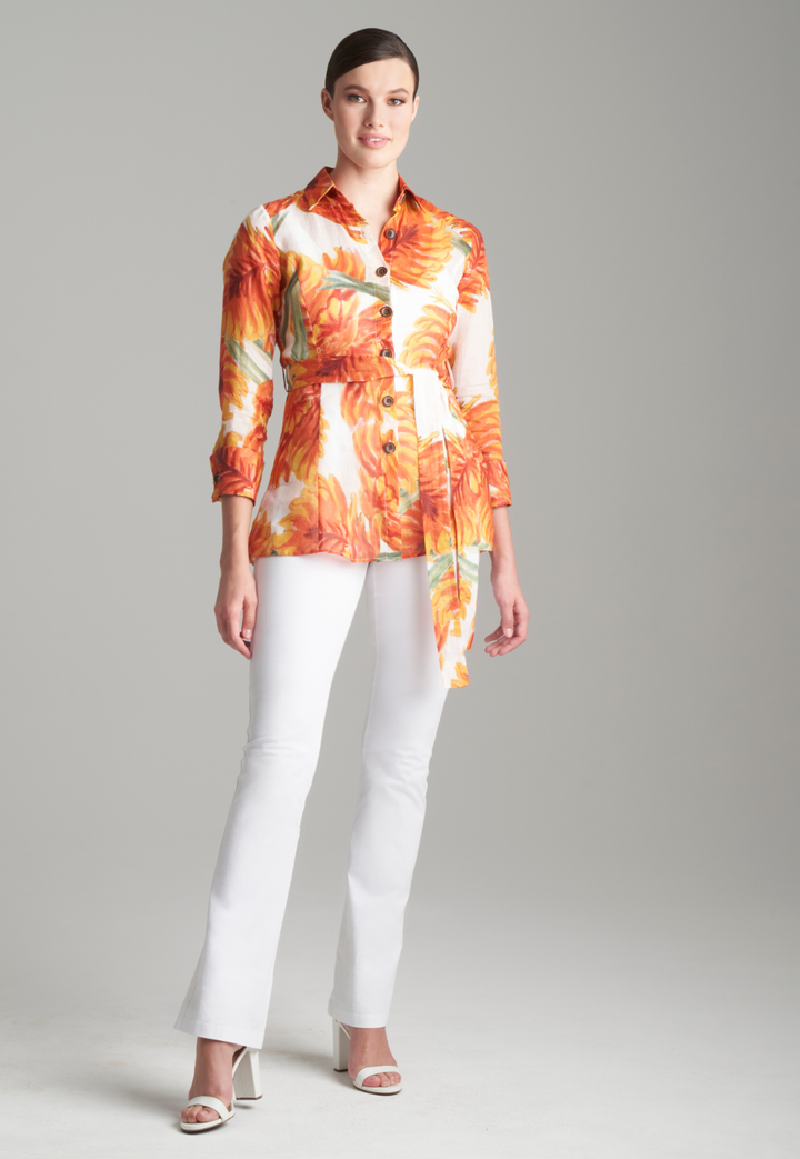Woman wearing orange palm leaf printed cotton shirt with self belt and white italian stretch cotton pants
