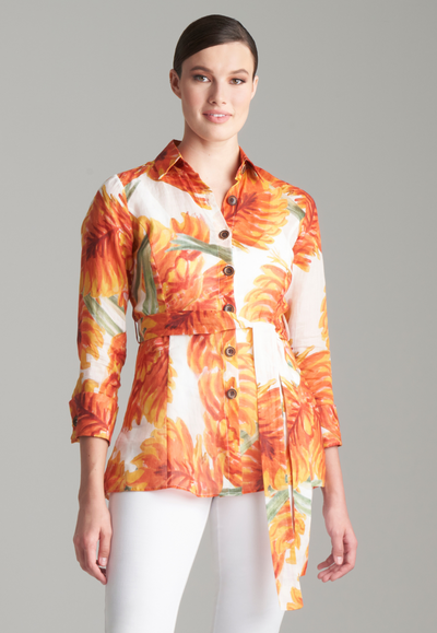 Woman wearing cotton shirt in an orange palm leaf print with white italian stretch cotton pants