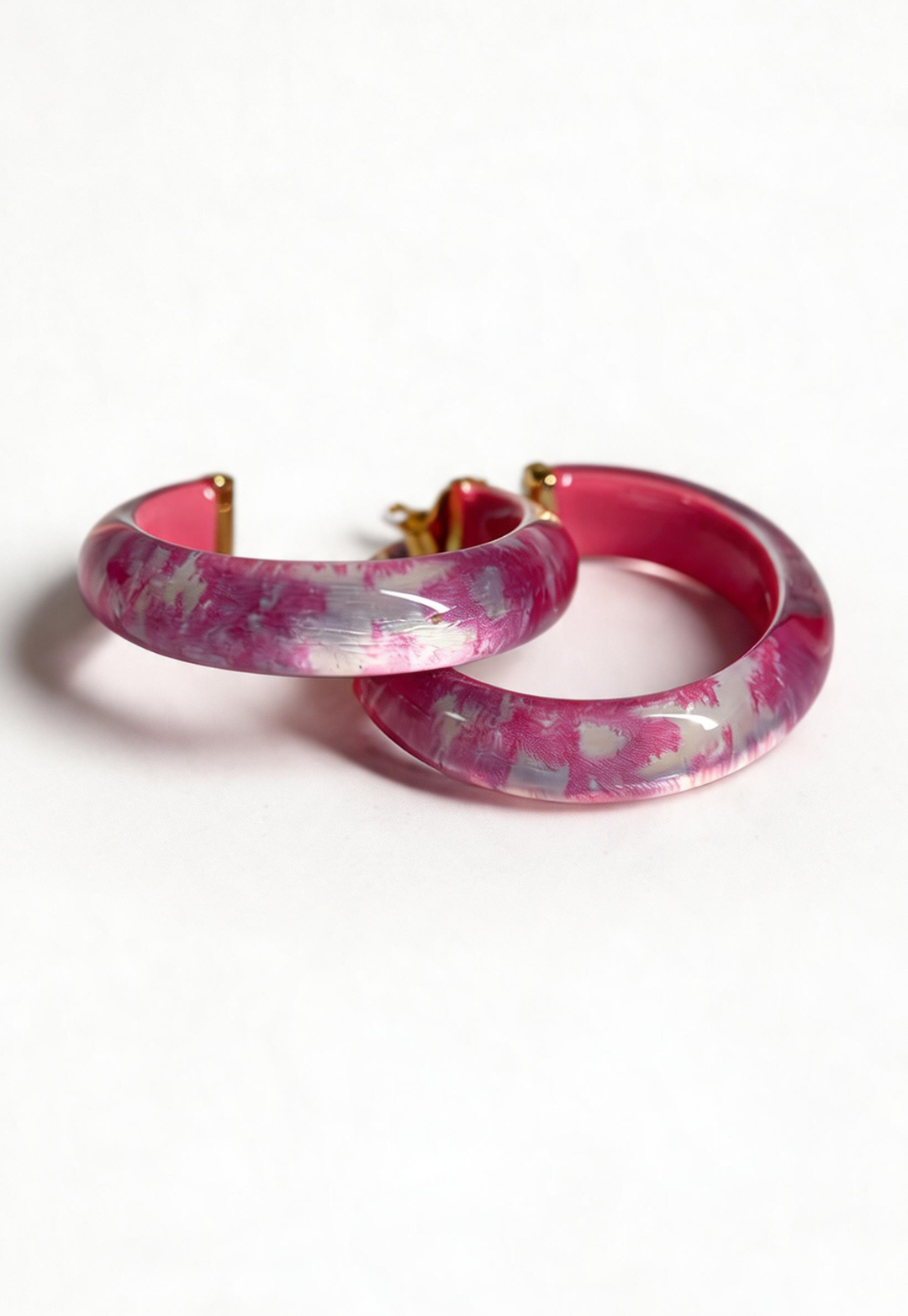 Pink marbled hoop earrings on a white background