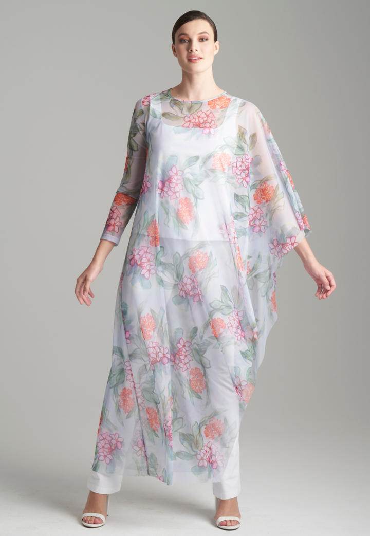 Woman wearing floral printed mesh kaftan over white tank top and pants in italian stretch cotton by Ala von Auersperg for summer 2024
