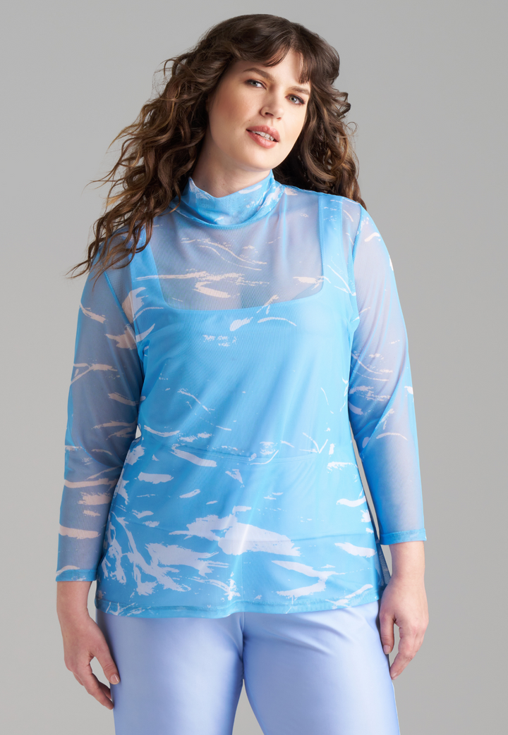 Woman wearing wave printed blue mesh turtleneck over stretch knit tank top and pants by Ala von Auersperg for summer 2023