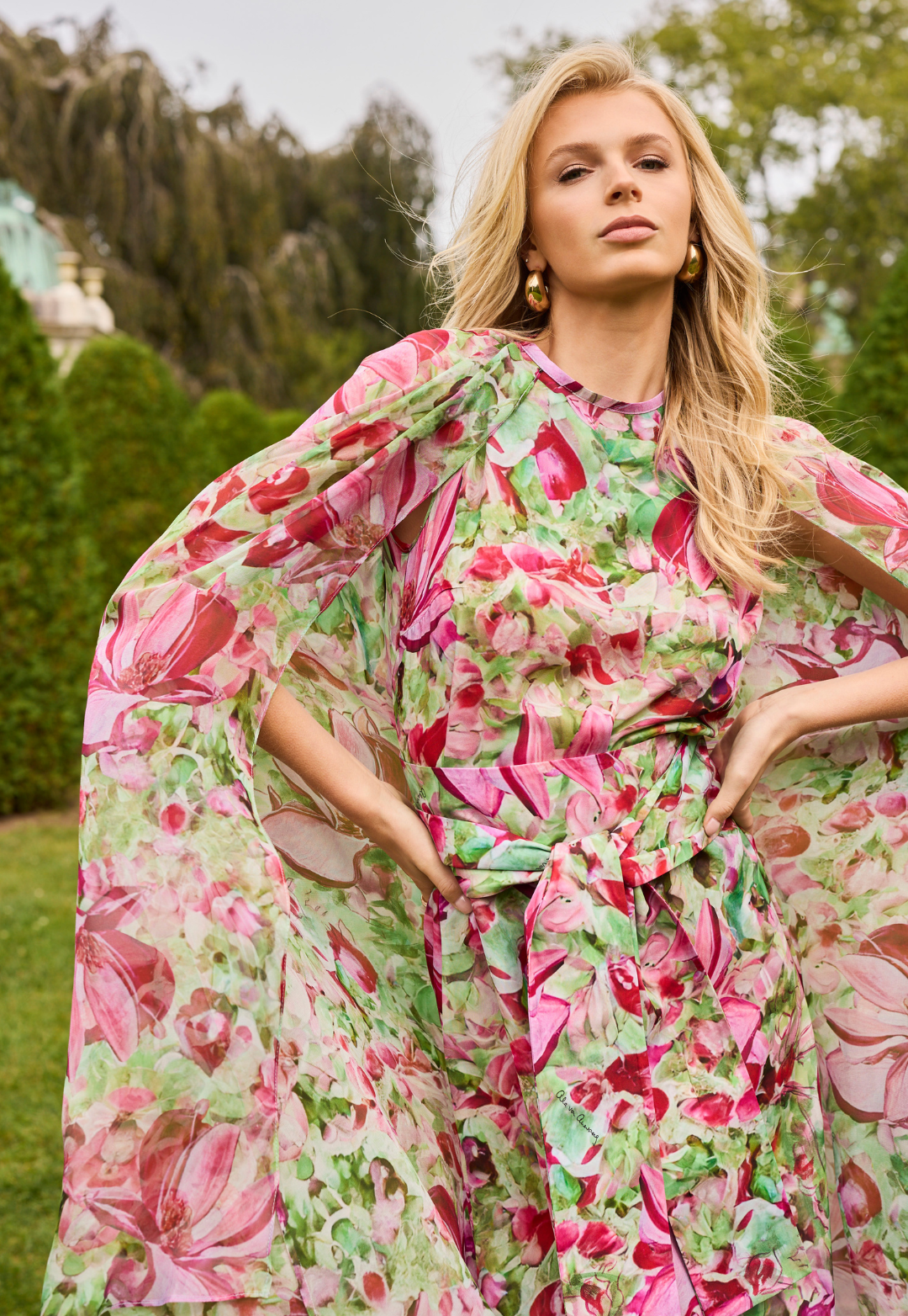 Woman wearing a pink and green floral dress in an outdoor setting