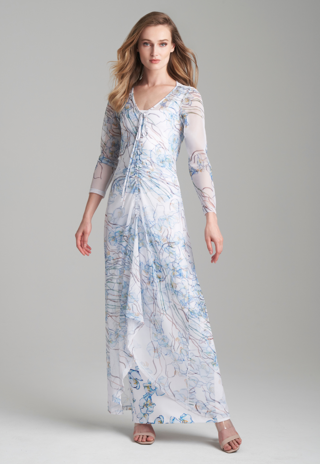 Woman wearing mesh drawstring sheer dress over long stretch knit white dress with blue orchids by Ala von Auersperg for spring 2024