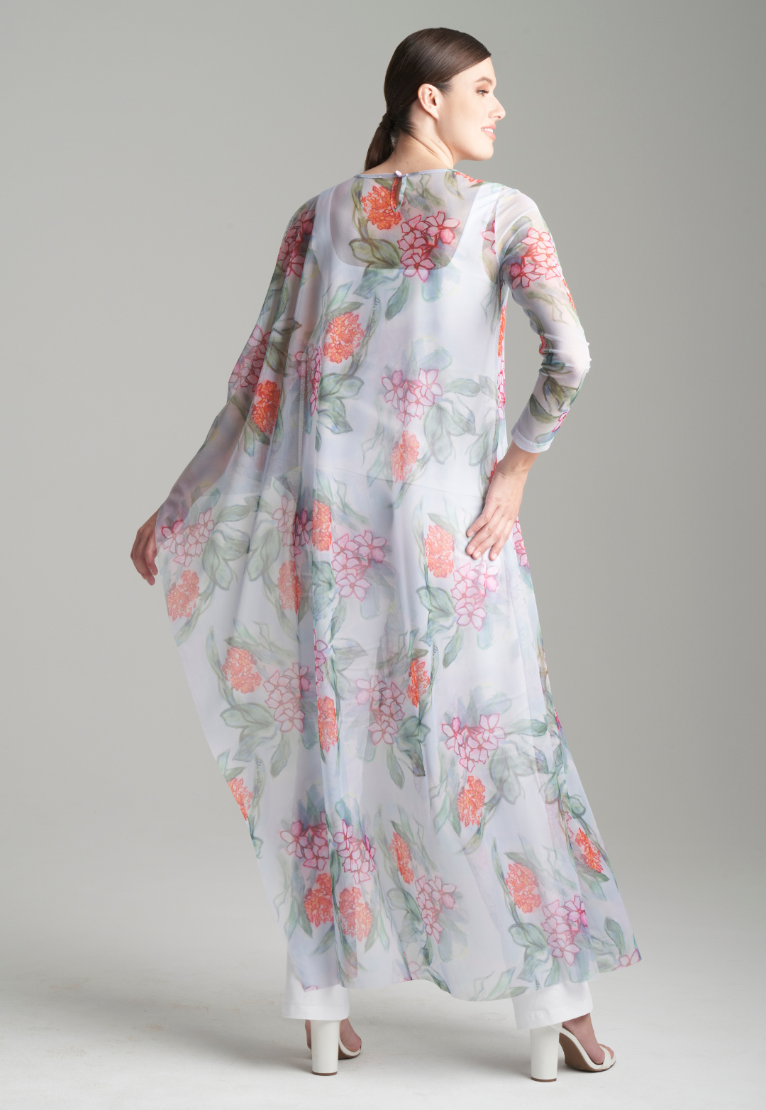 Woman wearing one armed mesh kaftan over white italian stretch cotton tank top and pants by Ala von Auersperg for summer 2024