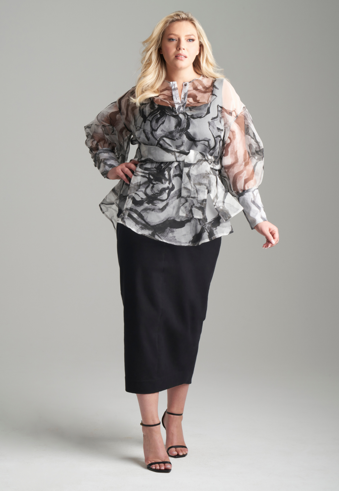 Woman wearing black rose printed silk organza balloon blouse with belt over black italian stretch cotton tank top and pencil skirt by Ala von Auersperg