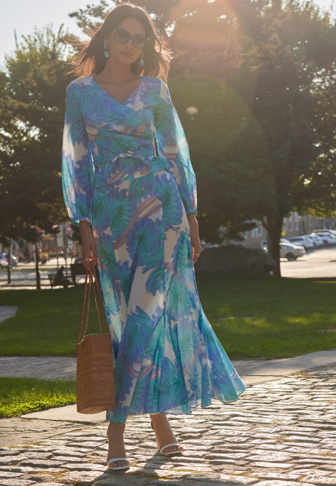 Woman in downtown city wearing blue palm leaf printed cotton wrap top with matching cotton skirt with flounce by Ala von Auersperg for spring 2024