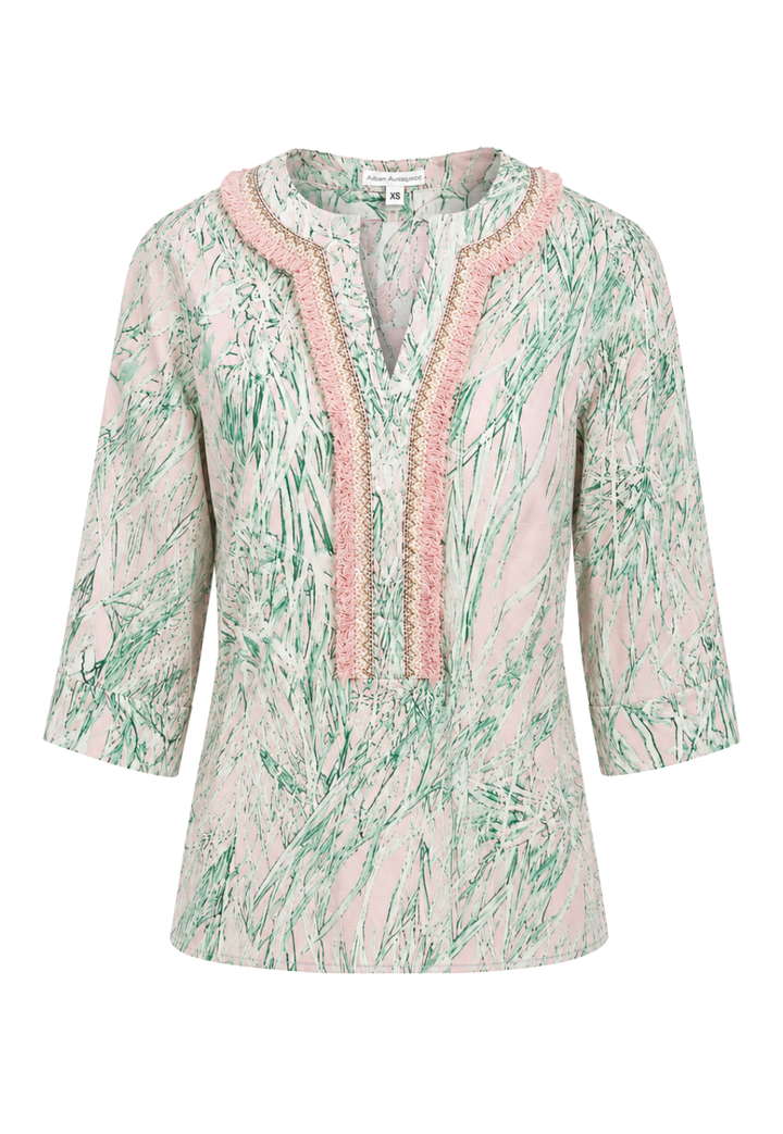 Light pink and green patterned top with lace trim on a white background