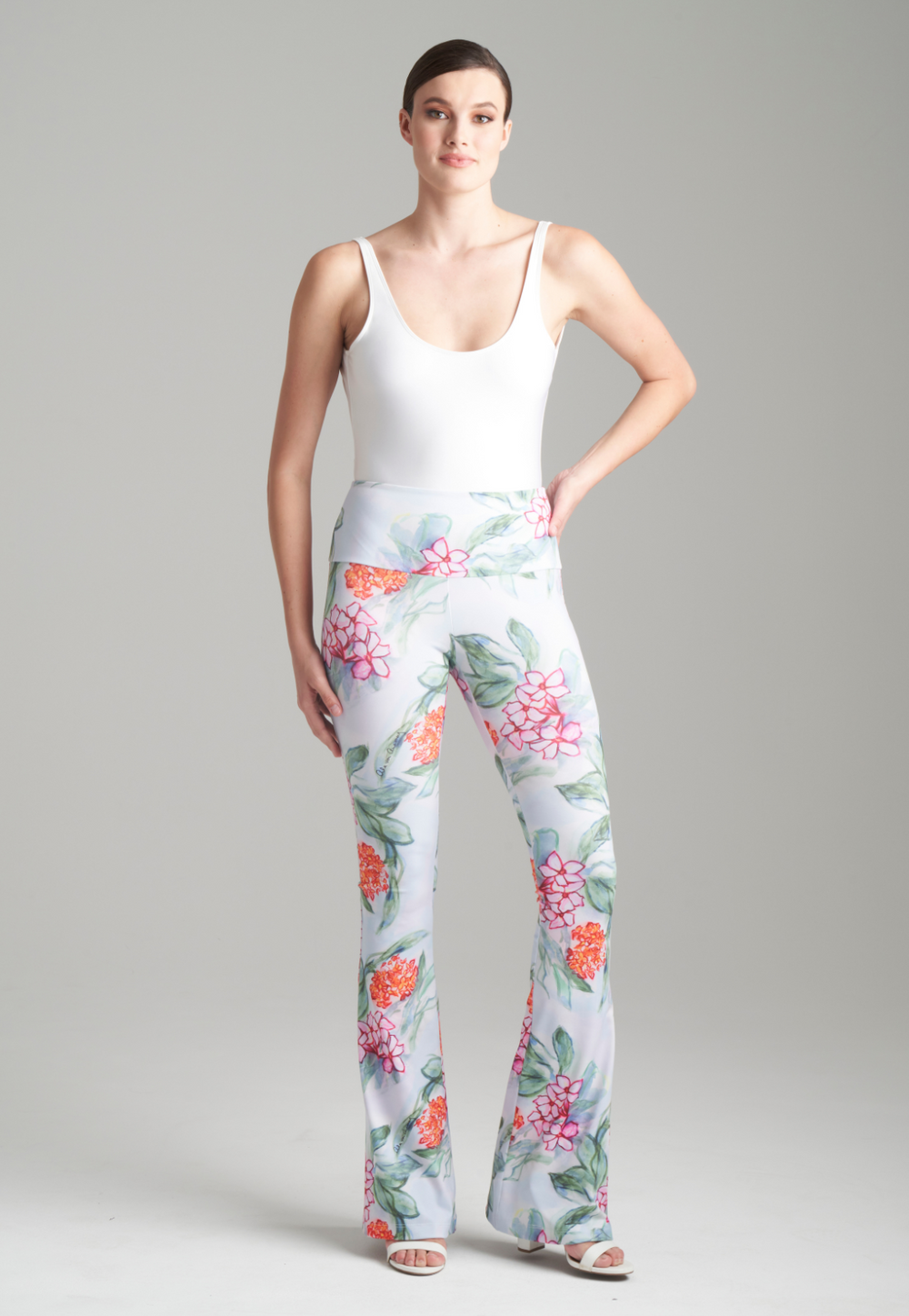Woman wearing floral printed stretch knit yoga pants with a white tank top by Ala von Auersperg for spring 2024