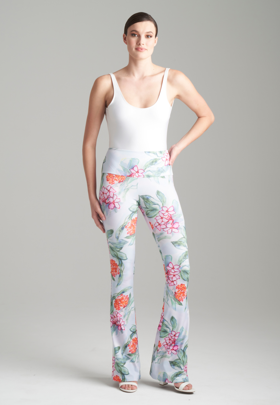 Woman wearing floral printed stretch knit yoga pants with a white tank top by Ala von Auersperg for spring 2024