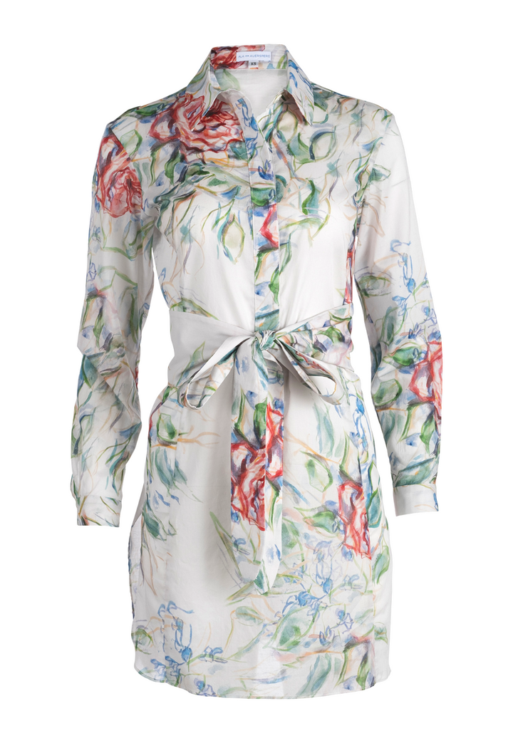 Woman wearing rose printed cotton tunic with belt and italian stretch cotton white pants by Ala von Auersperg