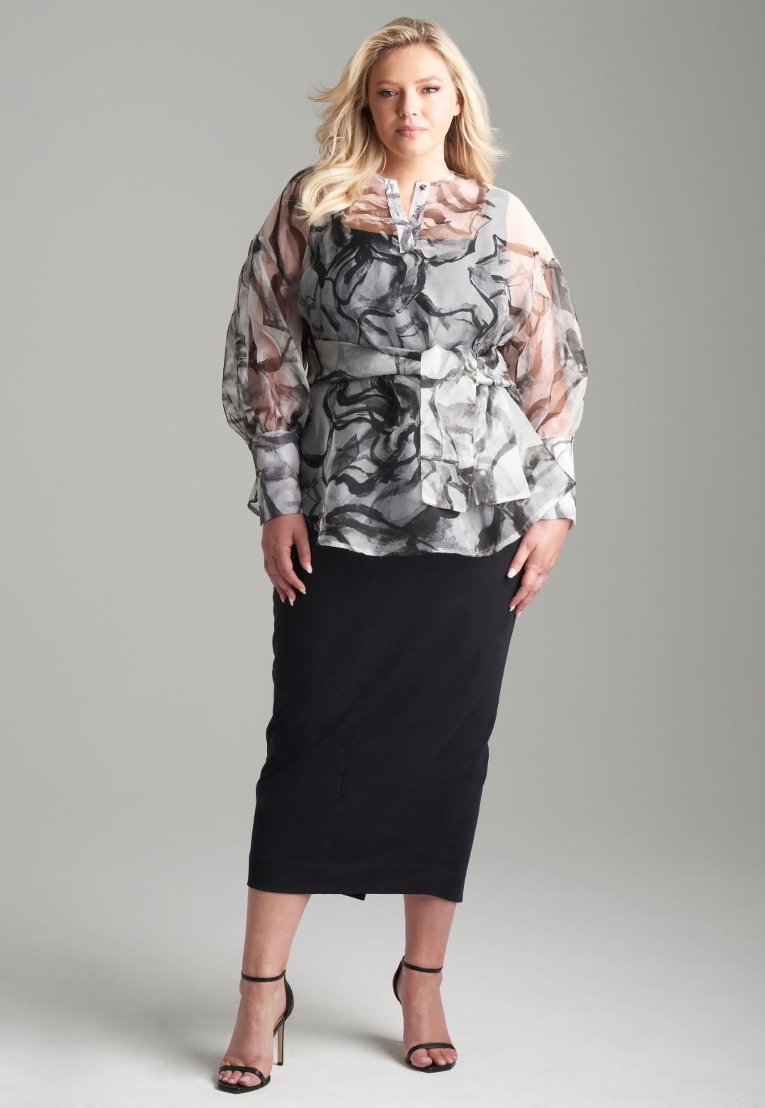 Woman wearing black rose printed silk organza balloon blouse with belt over black italian stretch cotton tank top and pencil skirt by Ala von Auersperg
