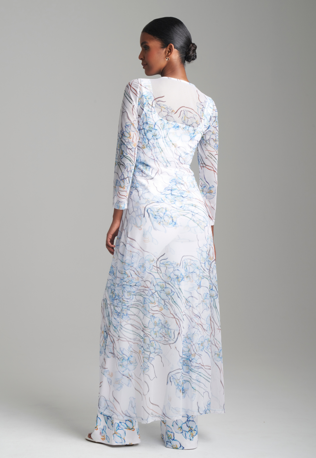 Woman wearing mesh drawstring orchid printed outfit topper over matching stretch knit tank top and pants by Ala von Auersperg for spring 2024