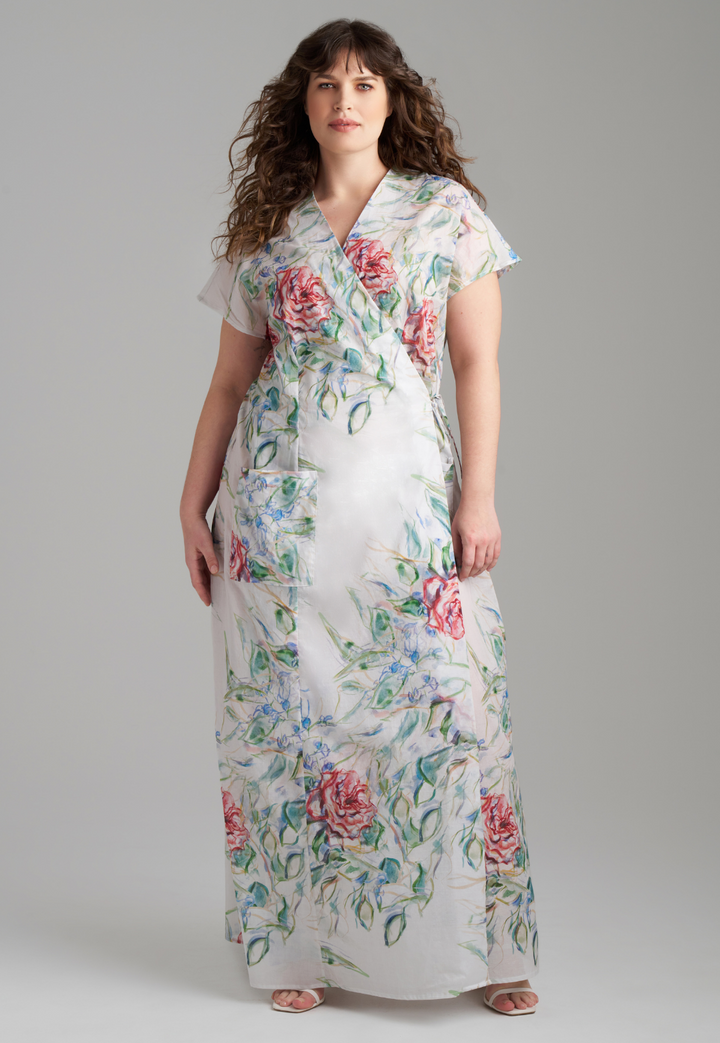Woman wearing rose printed cotton wrap dress with v neck, side tie, and short sleeves by Ala von Auersperg for summer 2023