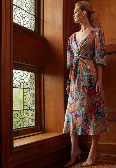 Woman wearing silk red orange floral printed short dress with front detailing for fall 2024