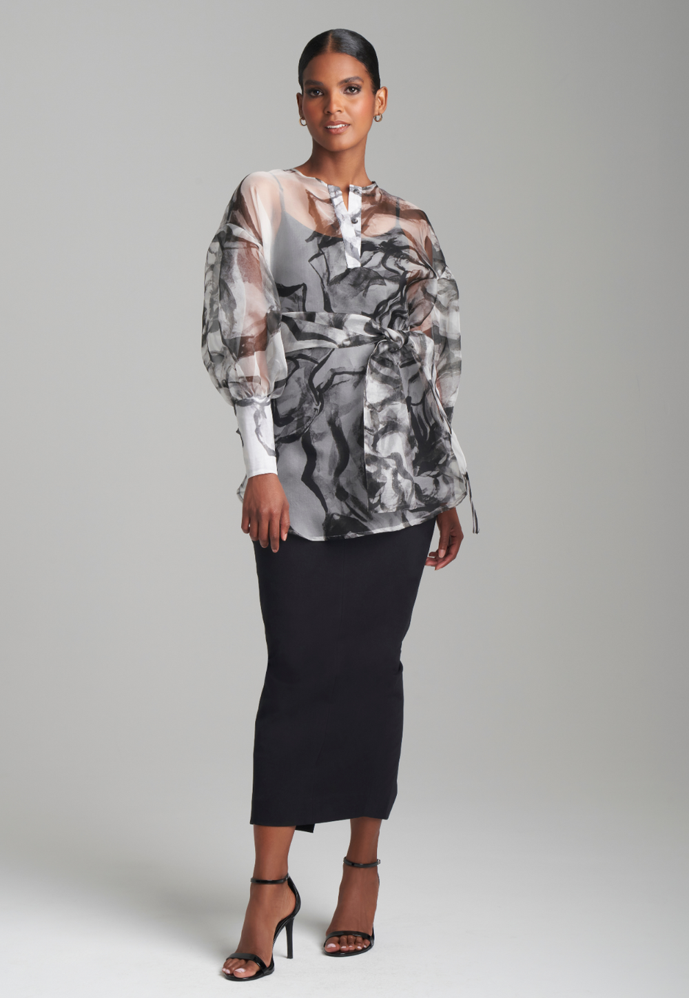 Woman wearing black rose printed silk organza balloon blouse with belt over black italian stretch cotton tank top and pencil skirt by Ala von Auersperg