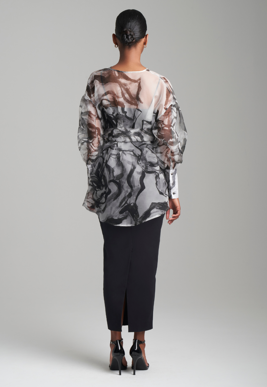 Woman wearing black rose printed silk organza balloon blouse with belt over black italian stretch cotton tank top and pencil skirt by Ala von Auersperg