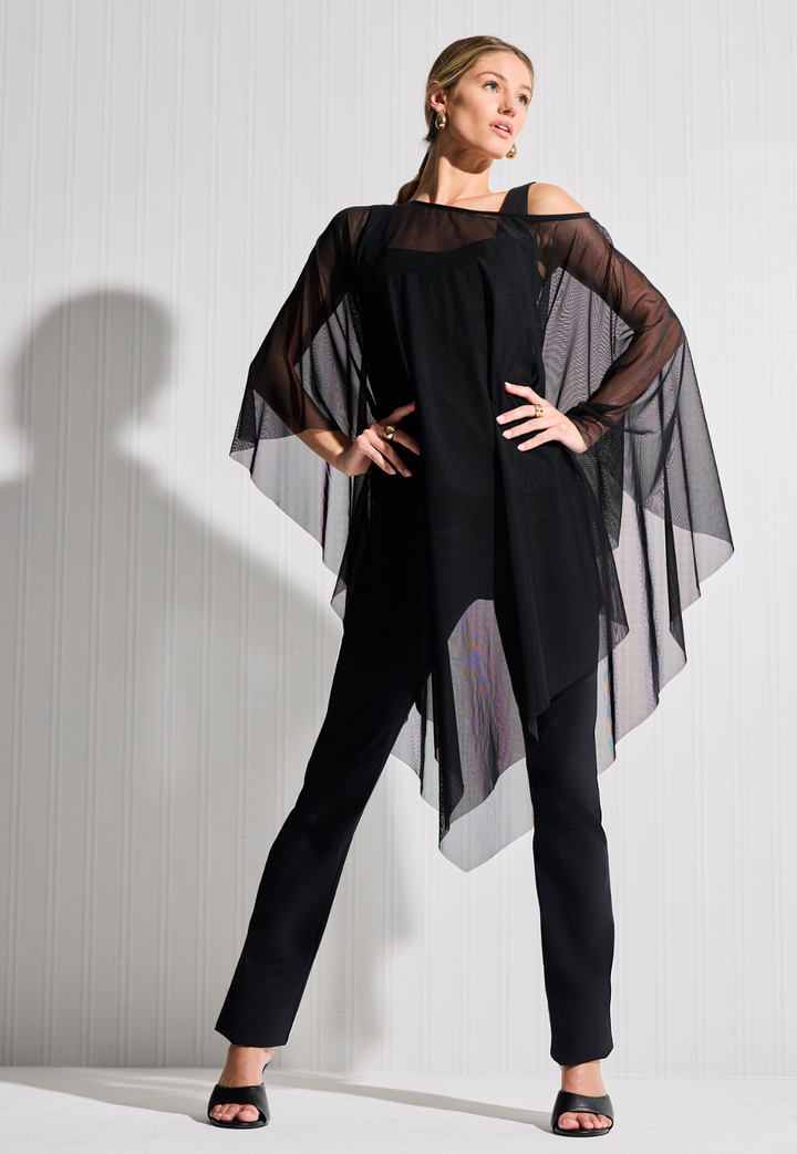 Woman wearing mesh sheer black poncho over black tank top and black pants by designer Ala von Auersperg for womens luxury travel clothing
