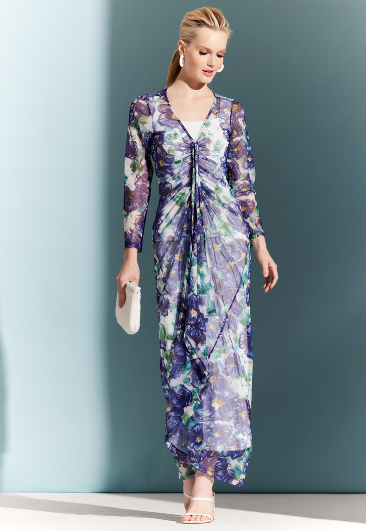 Woman wearing sheer drawstring dress topper over a white dress in a blue floral print by designer Ala von Auersperg for womens luxury travel clothing