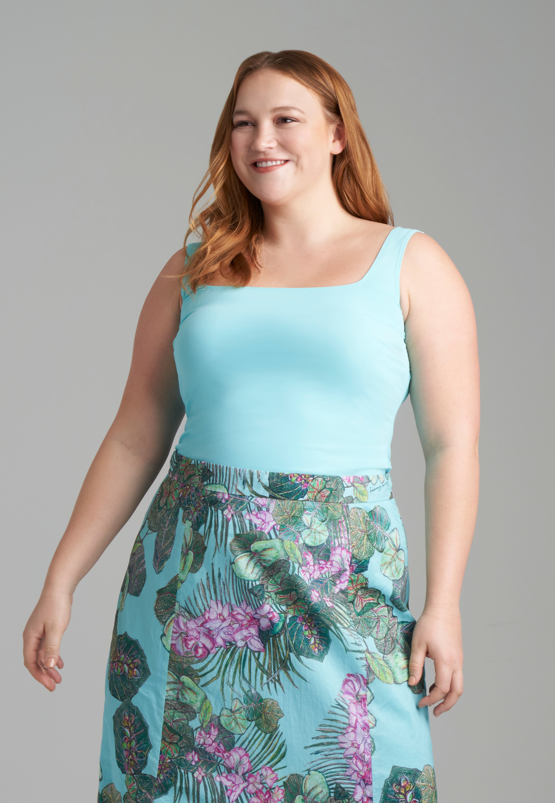 Woman wearing light blue tank top with cotton printed skirt by designer Ala von Auersperg for womens luxury travel clothing