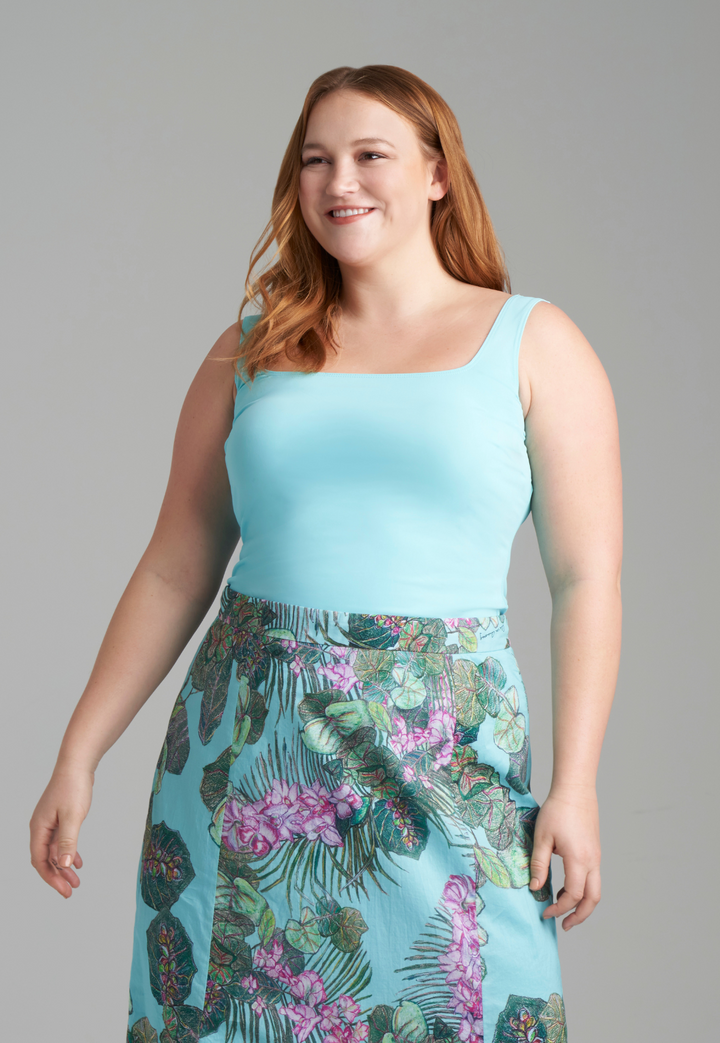 Woman wearing light blue tank top with cotton printed skirt by designer Ala von Auersperg for womens luxury travel clothing