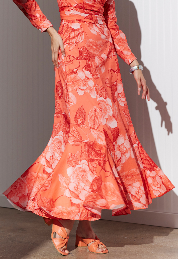 Woman wearing cotton red floral printed peasant skirt by designer Ala von Auersperg for women's luxury travel clothing