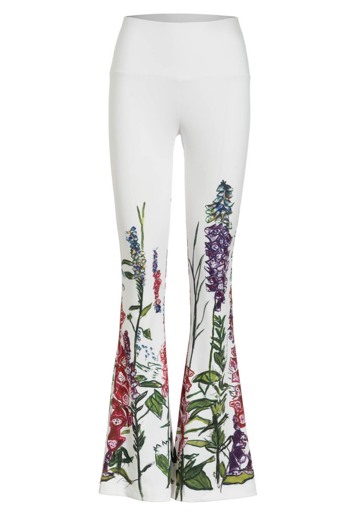 Flat image of a white stretch knit pants with a floral print by designer Ala von Auersperg for womens luxury travel clothing