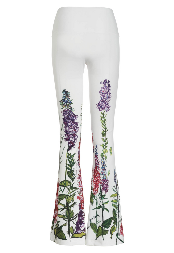 Flat image of white stretch knit pants with a floral print trim by designer Ala von Auersperg for womens luxury travel clothing