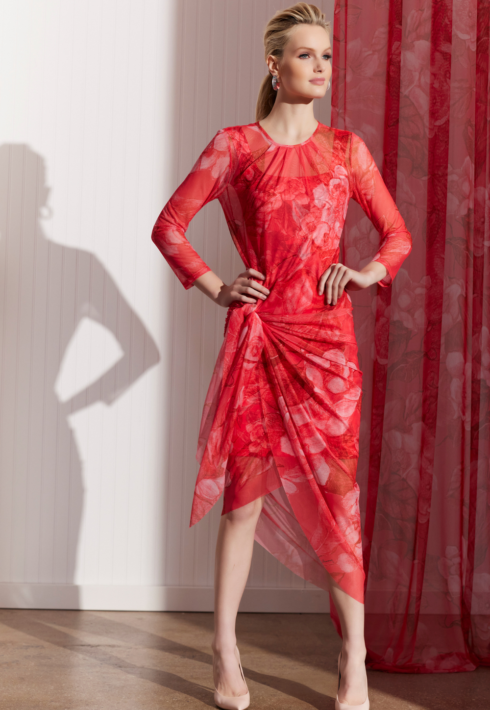 Woman wearing sheer red floral wrap dress over a matching short mini dress by designer Ala von Auersperg for women's luxury travel fashion